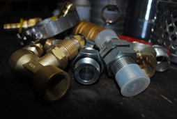 Brass and stainless steel hose fittings, two, four and six wire fittings, garden hose fitting, air hose fitting, AN fittings and adapters including a flat face adapter, JIC adapter, SAE adapter, two threaded pipe adapters, a British, German, Din and metric adapter and two compression adapters are shown here.